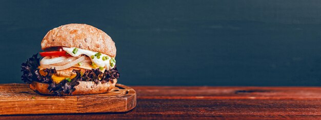 Tasty burger on wooden cutting board