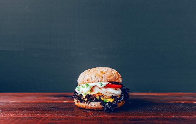 Tasty burger on wooden cutting board