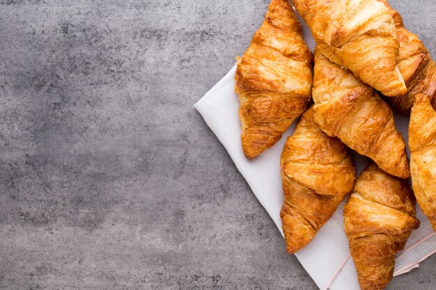 Tasty buttery croissants on old wooden table.