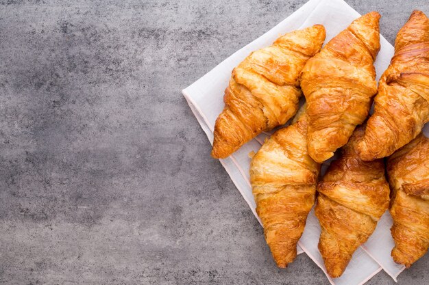 Tasty buttery croissants on old wooden table.