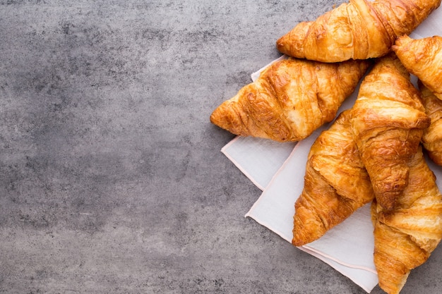 Tasty buttery croissants on old wooden table.