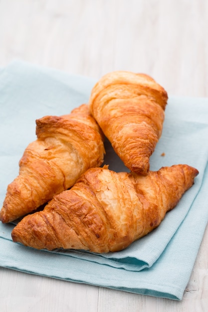 Tasty buttery croissants on old wooden table