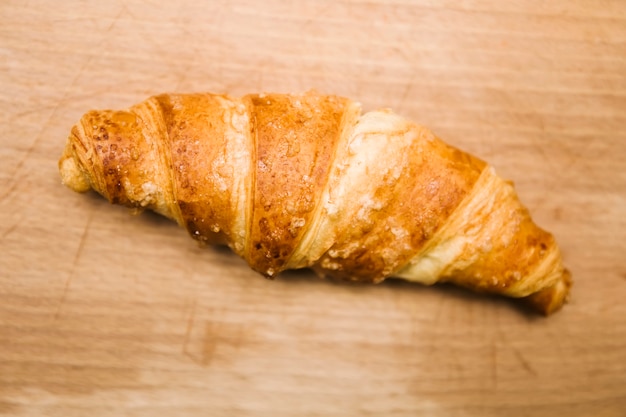 Tasty buttery croissants on old wooden table