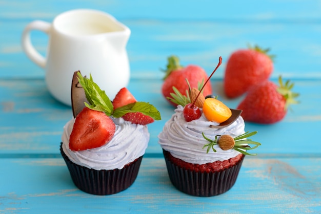 Tasty cake with pieces of fruits and strawberry on a table