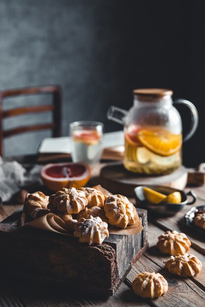 Tasty cakes with Hot tea with slices of fresh grapefruit on wooden tablet. Healthy drink, Eco, vegan