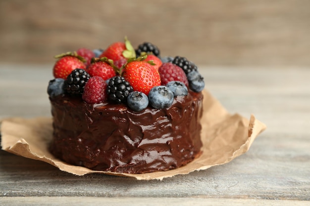 Tasty chocolate cake with different berries on wooden table