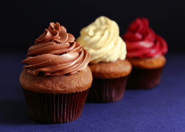 Tasty chocolate cupcake on dark background