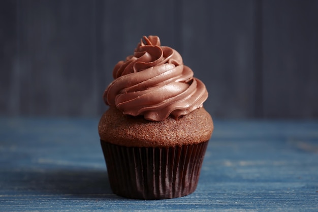 Tasty chocolate cupcake on wooden table