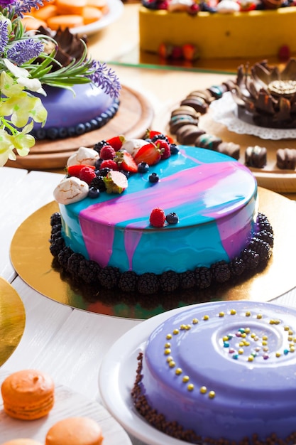 Tasty colorful cakes on the showcase with fresh summer berries