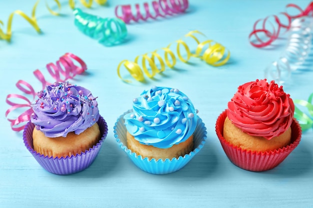 Tasty colorful cupcakes on wooden table