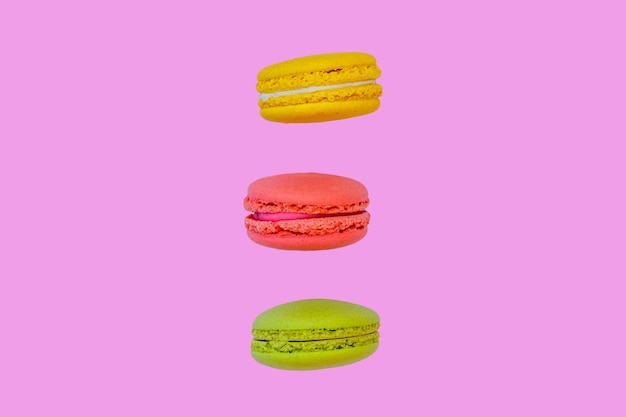 Tasty colorful macaroons on pink background