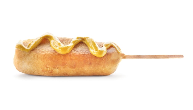 Tasty corn dog with mustard on white background