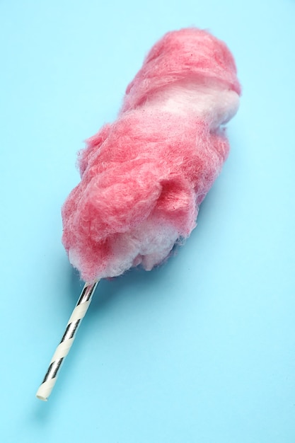 Tasty cotton candy on color background