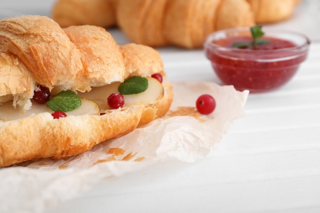 Tasty croissant with filling on table