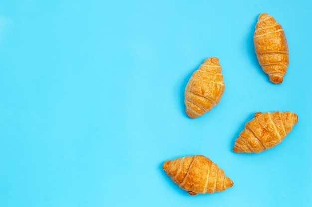 Tasty croissants on blue background.