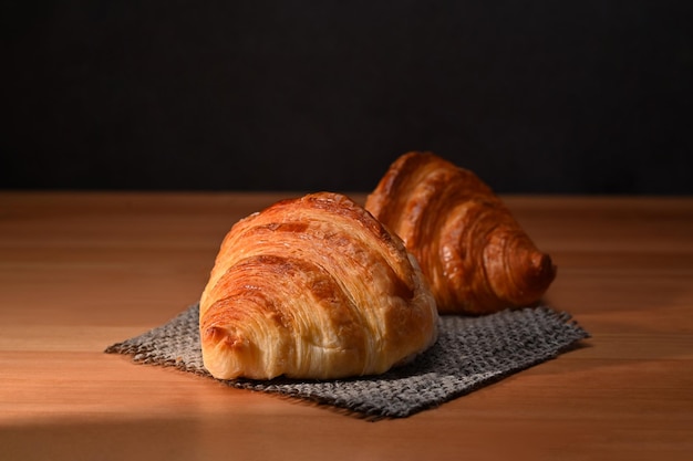 Tasty crusty butter croissants on wooden table Breakfast bread bakery products cafe concept