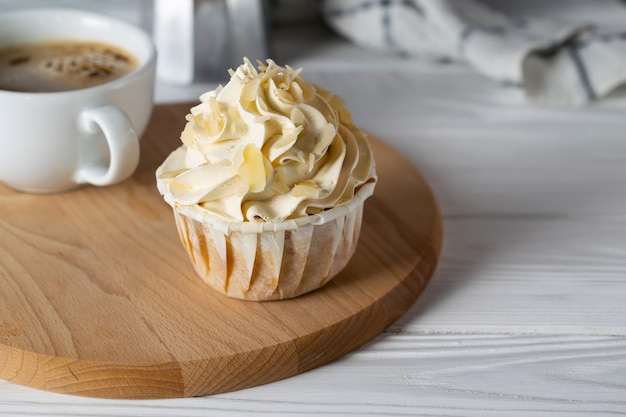 Tasty cupcake with almond flavor frosting with cup of coffee