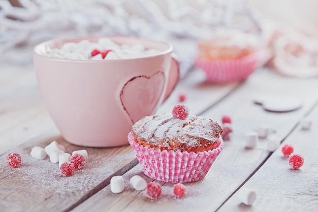 Tasty cupcake with berries and cup of coffee