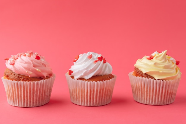 Tasty cupcakes sweets on pink  close up