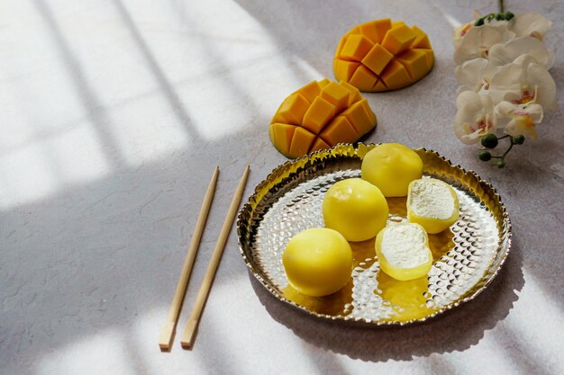 Tasty dessert Mochi with mango fruit on grey background close up