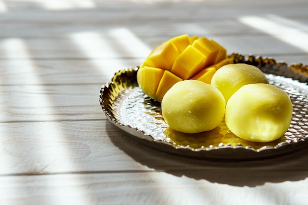 Tasty dessert Mochi with mango fruit on wooden background close up