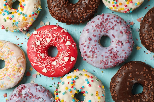 Tasty donuts on blue background, top view