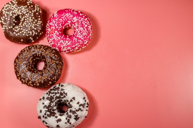 Tasty donuts on pink background Top view copy space