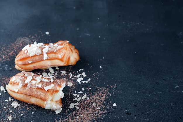 Tasty eclairs on table