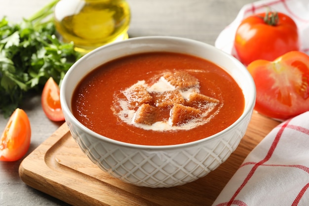 tasty food with tomato soup on gray