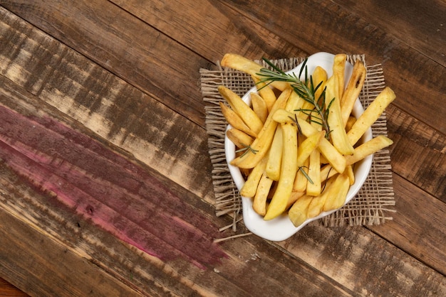 Tasty french fries on plate on bowl