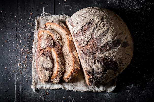 Photo tasty and fresh bread with whole grains on dark table