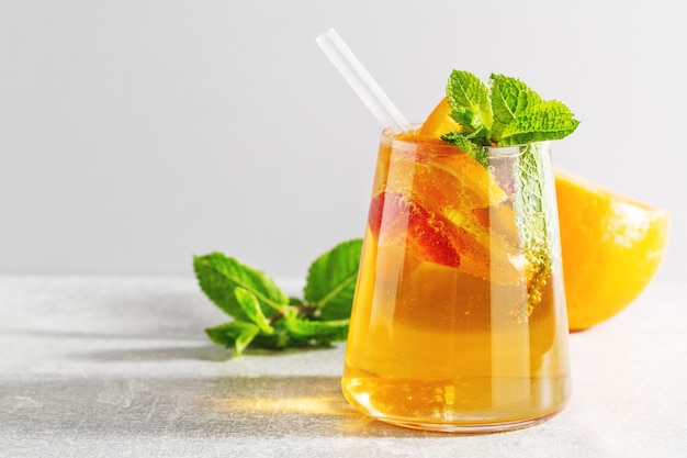 Tasty fresh drink with orange strawberry and mint served in glass. Closeup