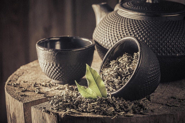 Tasty and fresh green tea with iron teapot and cup