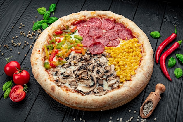 Tasty fresh pizza with four different pieces in one on wooden background Top view of big pizza