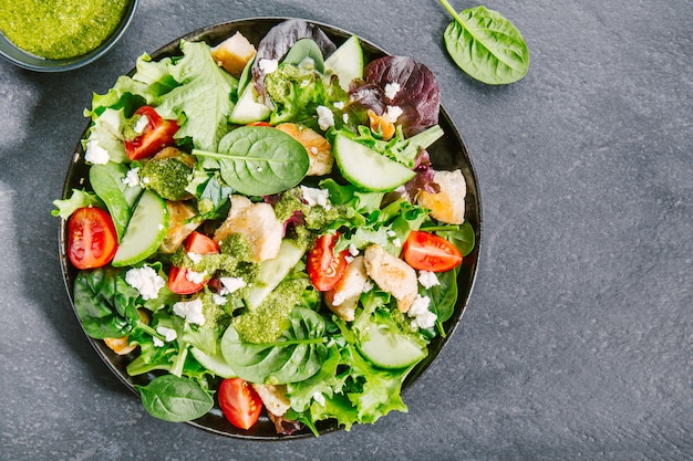 Tasty fresh salad with chicken, pesto and vegetables