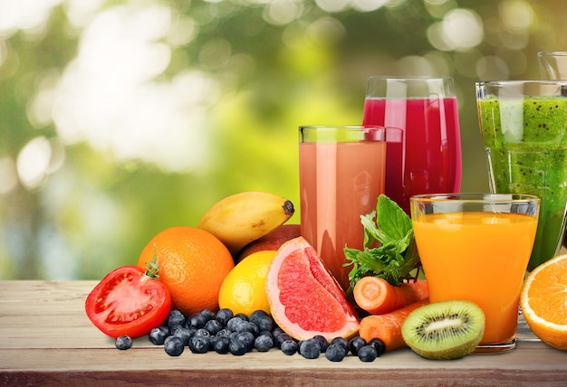 Tasty fruits  and juice with vitamins on background