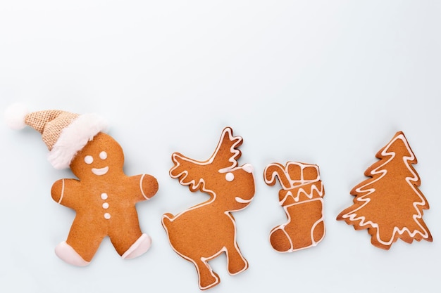 Tasty gingerbread cookies and Christmas decor on pastel background.