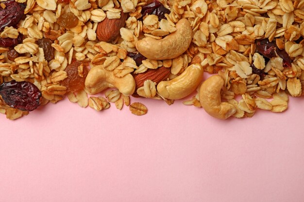 Tasty granola on pink background isolated