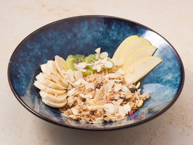 Tasty granola with fruit on a dark plate as breakfasts good nutrition concept