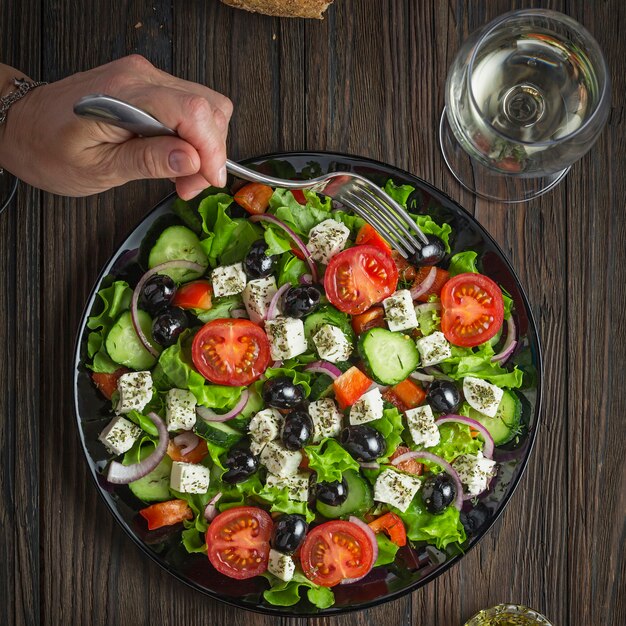 Tasty greek salad on a black plate