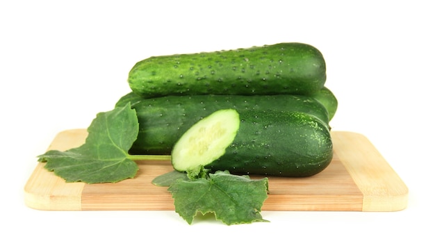 Tasty green cucumbers on wooden cutting board, isolated on white