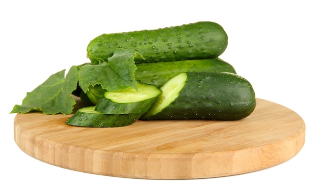 Tasty green cucumbers on wooden cutting board isolated on white