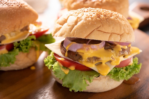 Tasty grilled home made burgers with beef,  tomato,  cheese,  cucumber and lettuce