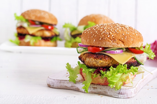 Tasty grilled homemade hamburger with burger chicken, tomato, cheese, cucumber, lettuce and beetroot. Sandwich. Lunch