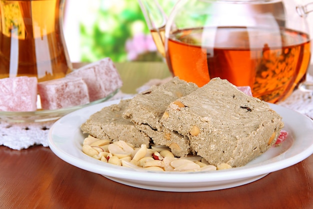 Tasty halva with tea on table in room