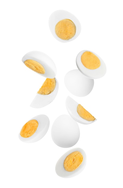 Tasty hard boiled eggs falling on white background