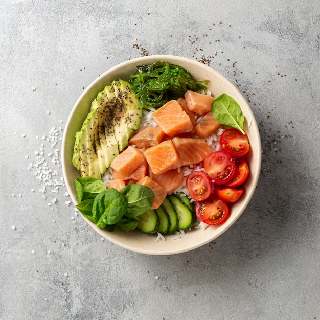 Tasty and healthy food concept Organic poke bowl with salmon, avocado, vegetables and chia seeds