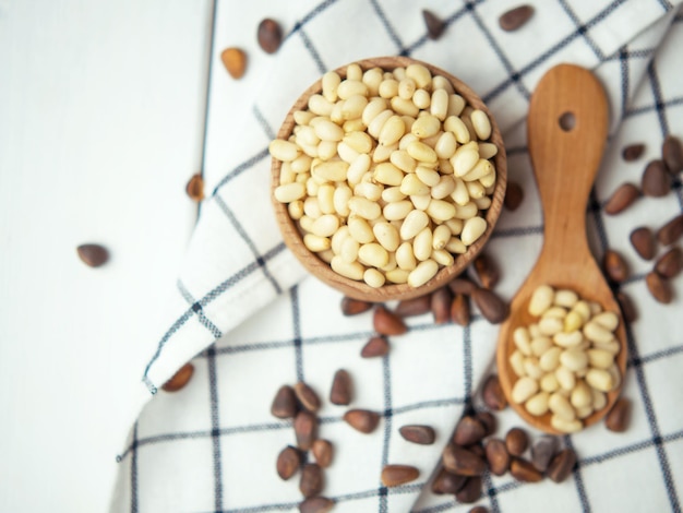 Tasty and healthy pine nuts in a wooden bowl and spoon