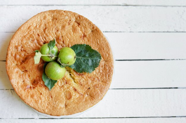 Tasty homemade apple pie on white wooden with copy space