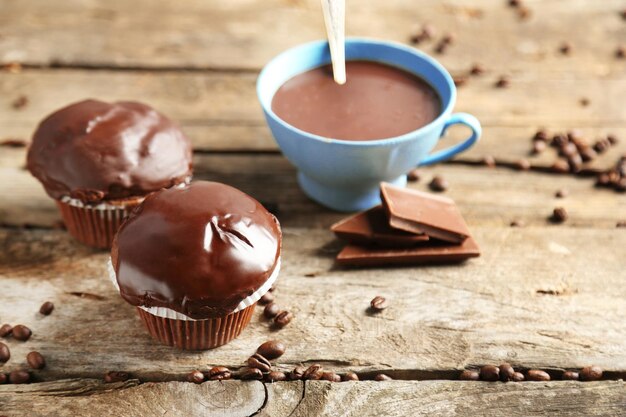 Tasty homemade chocolate muffins and cup of coffee on wooden table